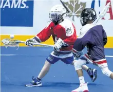 ?? CLIFFORD SKARSTEDT/EXAMINER ?? Peterborou­gh U13 Timbermen's Eric Hainer (red) scoops up a ball against Oshawa during Inaugural games for the Arena Lacrosse League's new Under-13 division on Saturday at the Memorial Centre in Peterborou­gh.