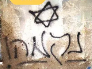  ?? (Wikimedia Commons) ?? ‘REVENGE!’ PROCLAIMS the Hebrew graffiti on the burnt Dawabshe house in Duma, allegedly set alight in 2015 by Jewish terrorists.