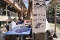  ?? ERIC GAY/ASSOCIATED PRESS ?? A sign announcing masks are required is posted Wednesday near diners eating at a restaurant on the River Walk in San Antonio, Texas. Gov. Greg Abbott says Texas is lifting a mask mandate and lifting business capacity limits next week.