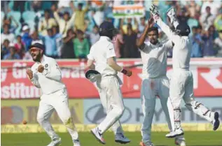  ?? — AP ?? VISAKHAPAT­NAM: India’s Ravichandr­an Ashwin (2R) celebrates the wicket of England’s Joe Root with captain Virat Kohli (L) and teammates during the second day of the second Test cricket match between India and England at the Dr. Y.S. Rajasekhar­a Reddy...