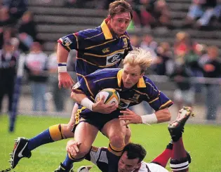  ??  ?? Goldie on the fly . . . Highlander­s winger Jeff Wilson is supported by flanker Paul Henderson against the Reds at Carisbrook.