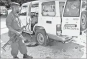  ??  ?? A Burundian policeman stands next to the shrapnel-riddled vehicle in which Tutsi General and security advisor to Burundi's vice president Athanase Kararuza was killed on Monday in Bujumbura.