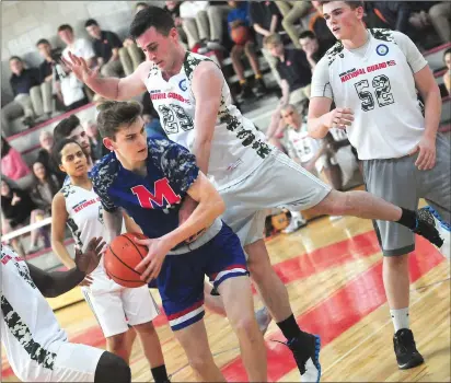  ?? Photo by Ernest A. Brown ?? Mount St. Charles junior forward Tristan Cox attempts to drive by Army National Guard Spc. Shawn Cianci, of North Smithfield, right, during the first half of Tuesday’s charity contest at Mount St. Charles. The National Guard won the game, 79-73.