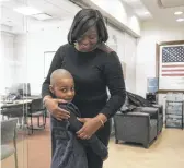  ?? ?? Ariana Roby, wife of fallen Chicago Fire Department firefighte­r Jermaine Pelt, hugs their 6-year-old son Jared. She said the $11,000 her son received on Monday will help pay for living expenses and college.