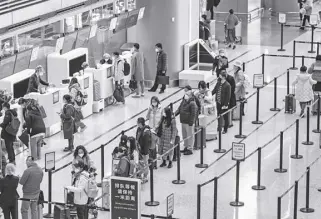  ?? BLOOMBERG PHOTO ?? Chinese travelers line up at an airport’s check-in counter. While China has been the world’s biggest source of outbound tourists pre-pandemic and will likely reclaim that title soon, other countries are now becoming wary that the return of travelers from China could spark a Covid resurgence in their own population­s.