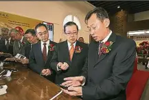  ??  ?? 王宏偉（右一）講解手機銀行的操作程­序，為客戶帶來便利又安全­的服務，右二起為林冠英及吳駿。