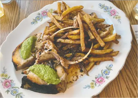  ?? PETER HUM ?? Le Poisson Bleu's play on steak frites swaps in a large chunk of dry-aged striped bass ($76 for an 11-ounce steak).