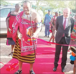  ?? ?? His Majesty King Mswati III cuts the ribbon to mark the official opening of Malkerns Square, while Afican Alliance’s Tony de Castro (R) looks on.