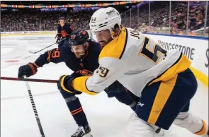  ?? ?? The Canadian Press
Nashville Predators’ Roman Josi and Edmonton Oilers’ Leon Draisaitl battle for the puck during third-period NHL action in Edmonton on Jan. 27.