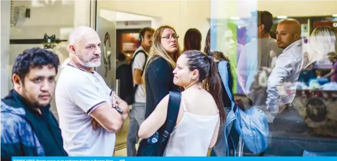  ??  ?? BUENOS AIRES: People queue at an exchange bureau in Buenos Aires. — AFP