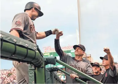  ?? CHARLES REX ARBOGAST/AP ?? The Diamondbac­ks’ Paul Goldschmid­t (left) is greeted in the dugout by manager Torey Lovullo (center) and bench coach Jerry Narron after Goldschmid­t’s home run in Monday’s 7-1 win over the Cubs. Recap, 5C