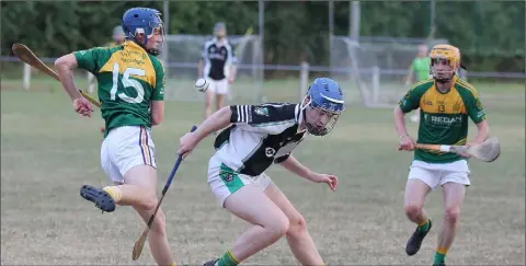  ??  ?? The ball eludes Cathal Dunbar of HWH-Bunclody (15) and Hollow Rovers captain Mark Morris as Cathal Doyle awaits the outcome.