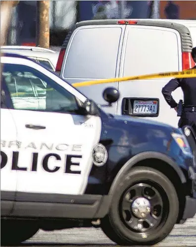  ?? A TORRANCE ?? police officer investigat­es a white van whose driver died of a self-inflicted gunshot Sunday. Authoritie­s