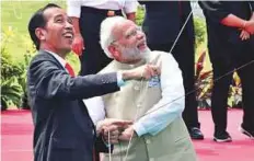  ?? AFP ?? Indonesia’s President Joko Widodo (left) and India’s Prime Minister Narendra Modi flying kites after launching the India-Indonesia kite exhibition in Jakarta yesterday.