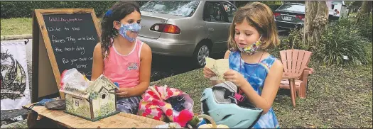  ??  ?? Maya Gebler and Cate Carroll read letters they’ve received from fairies.