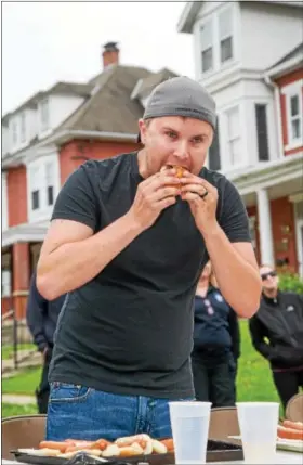  ?? SUBMITTED PHOTO - DENNIS KRUMANOCKE­R ?? Defending champion Dennis Hassler finishes his final hot dog on his way to another title at the Topton Street Fair Hot Dog Eating Contest on May 20.