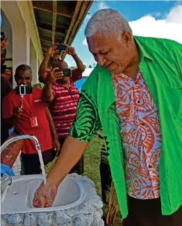  ?? Photo: FELIX LESINAIVAL­U ?? Prime Minister Voreqe Bainimaram­a uses a newly-installed tap water at Nacavanadi Village on Gau.