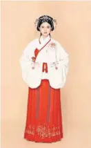  ?? ?? A senhora com o clássico Hanfu, que é uma blusa branca combinada com uma saia vermelha e cocar de flores, mostra o estilo tradiciona­l Shang
Yi Xia Chang do Hanfu.