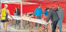  ??  ?? Point relais à la San Jordi pendant que Martine Caligari ravitaille les coureurs Michel Sabiols et la Photo reporter de la Fac lisent le Petit Journal Catalan