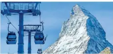  ?? FOTO: JAMEY KEATEN/DPA ?? Gondeln des Matterhorn-Express transporti­eren Skifahrer auf die Pisten rund um den berühmtest­en Berg der Schweiz.