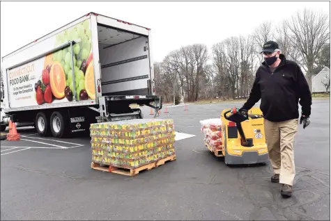  ?? Arnold Gold / Hearst Connecticu­t Media ?? Randy Thurlow, of the Connecticu­t Food Bank, unloads a pallet of pasta in the parking lot of the Kingdom Life Christian Church Cathedral in Milford for a mobile food distributi­on on Friday. The Kingdom Life Christian Church Cathedral and Cornerston­e Christian Center partnered with the Connecticu­t Food Bank for the effort.