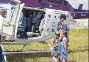  ?? NEWS PHOTO TIM KALINOWSKI ?? Russell Godin, with children Brooklyn and Kyler, gets a tour Tuesday of the HALO helicopter at the HALO 10-year anniversar­y party in Dunmore.