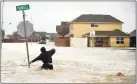  ?? JOE RAEDLE — GETTY IMAGES ?? A man tries to cross a flooded street.