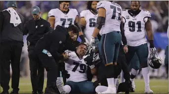  ?? ADAM HUNGER — THE ASSOCIATED PRESS ?? Eagles guard Brandon Brooks, center, is helped up by teammates and medical staff during a game against the Giants Dec. 29. Then, it was a dislocated shoulder that ended the Pro Bowler’s season. Monday, Brooks suffered his second torn Achilles’ tendon in three years, writing off the 2020 campaign.