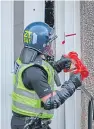  ??  ?? A police officer in the community investigat­ion unit forces entry to a property in Kirkcaldy.