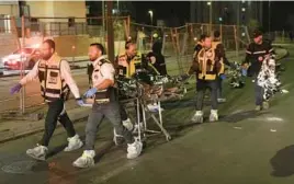  ?? MAHMOUD ILLEAN/AP ?? A rescue and recovery team removes a body after a deadly shooting attack Friday night near a Jerusalem synagogue while the Jewish Sabbath was being celebrated.