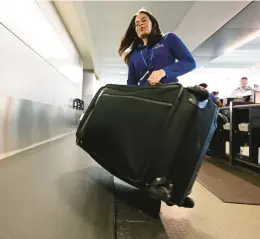  ?? RICK KINTZEL/THE MORNING CALL PHOTOS ?? Elizabeth Trinidad, of the Lehigh Northampto­n Airport Authority, places luggage on a conveyor belt Tuesday.