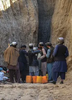  ?? — AFP photo ?? Rescuers try to reach and rescue a boy trapped for two days down a well in a remote southern Afghan village of Shokak, in Zabul province.