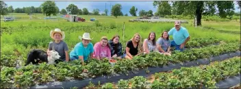  ??  ?? In their strawberry field, from left, are Gabe Henry with his dog, Ace, and Katie, Caroline, Savannah, Scout, Morgan, Jamie and Tom Henry. Not shown is Alexis Henry, who lives in Kansas.