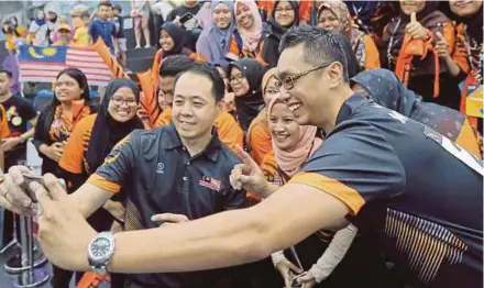  ?? PIC BY DANIAL SAAD ?? It’s selfie time with supporters after Alex Liew (centre) and Syafiq Ridhwan won gold in the doubles bowling event yesterday.