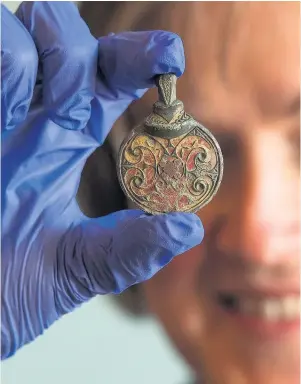  ??  ?? > An Anglo-Saxon hanging bowl mount from AD 600-725, found in West Sussex