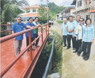  ??  ?? Jamit (second left) stands on the steel bridge across Sungai Selepong. With him are (from left) Tan, Bandang, Yong, Kong, Sia, Yap and Wong.