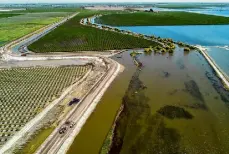  ?? Carlos Avila Gonzalez/The Chronicle ?? Heavy equipment is used to strengthen a levee to protect the Kings County city of Corcoran from flooding in 2023, the result of groundwate­r pumping.