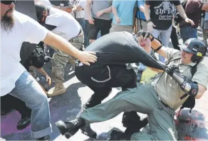  ?? Chip Somodevill­a, Getty Images ?? White nationalis­ts, neo-nazis and members of the "alt-right" clash with counter-protesters as they enter Lee Park during the "Unite the Right" rally August 12 in Charlottes­ville, Virginia.