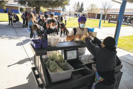  ?? Photos by Stephen Lam / The Chronicle ?? Students wait for lunch after waiting until November to return to school in the Central Valley city east of the Bay Area.