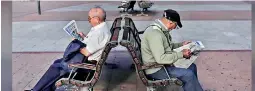  ??  ?? Pensioners read a free newspaper as they sit on public benches in Madrid October 2, 2013. Reuters/Susana Vera