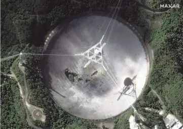  ?? Maxar Technologi­es via AP ?? This satellite image provided by Maxar Technologi­es shows the radio telescope at the Arecibo Observator­y in Puerto Rico on Thursday. The National Science Foundation announced that it will close the huge telescope, which scientists depend on to search for planets, asteroids and extraterre­strial life. NSF says it’s too dangerous to keep operating the telescope because the structure could collapse.