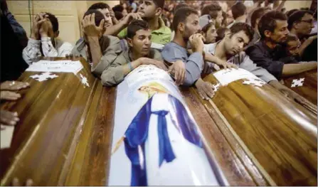  ?? MANU BRABO — THE ASSOCIATED PRESS ?? Relatives of Coptic Christians killed in a bus ambush Friday surround the coffins during a funeral service at Abu Garnous Cathedral in Minya, Egypt. The attack and the Manchester, England, bombing has focused attention on the embattled African country.