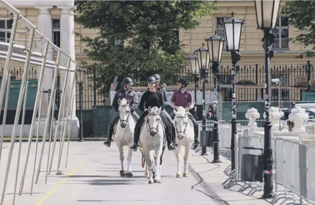  ??  ?? 0 Riders from the Spanish Riding School in Vienna, Austria, take advantage of the easing of restrictio­ns to take their horses to graze in the reopened federal park