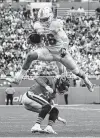  ?? Joel Auerbach / Associated Press ?? Miami tight end Mike Gesicki goes over the top of Chicago cornerback Kyle Fuller after catching a pass in the second half of Sunday’s game.