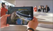  ??  ?? Visitors can experience Apple Park through augmented reality, viewing buildings and surroundin­g areas virtually using iPads.