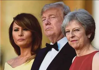  ?? AFP PIC ?? (From left) United States First Lady Melania Trump, US President Donald Trump and British Prime Minister Theresa May stand on steps in the Great Court as the bands of the Scots, Irish and Welsh Guards perform a ceremonial welcome at Blenheim Palace,...