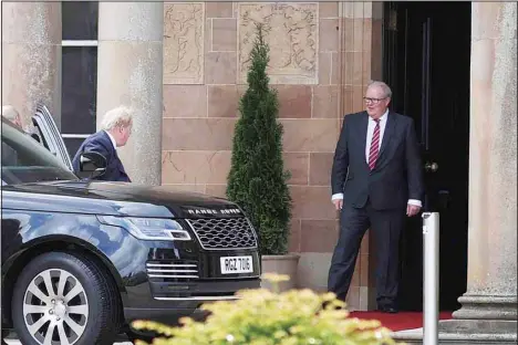  ?? ?? British Prime Minister Boris Johnson (left), gets out of a car as he is welcomed by Mark Larmour from the Northern Ireland Office upon his arrival at Hillsborou­gh Castle, Northern Ireland, Monday, May 16, 2022. Johnson on Monday renewed British threats to break a Brexit agreement with the European Union, blaming it for a political crisis that’s blocking the formation of a new government in Northern Ireland. (AP)