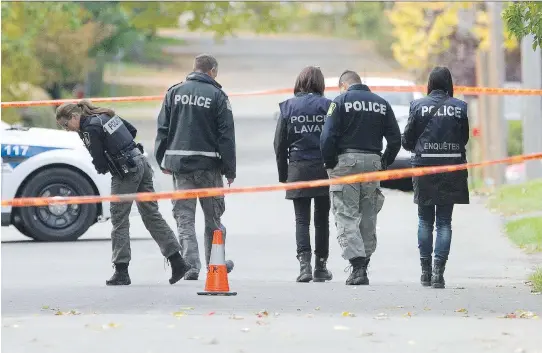  ?? PHIL CARPENTER/MONTREAL GAZETTE ?? Laval police officers survey the scene near where the body of a 19-year-old man was found on 20th St. near 36th Ave. on Wednesday. Police say the 19-year-old was bludgeoned to death by a hammer-wielding man, who allegedly attacked two other people and...