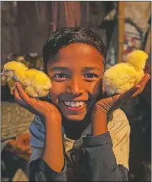  ??  ?? Imradul Ali displays at his home baby chicks which he found at a landfill.