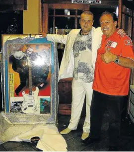  ??  ?? AXE MEN: Radovan Krejcir, left, and Lolly Jackson pose with the guitar that Jackson bought for R250 000. The instrument is autographe­d by its former owner, The Edge of U2